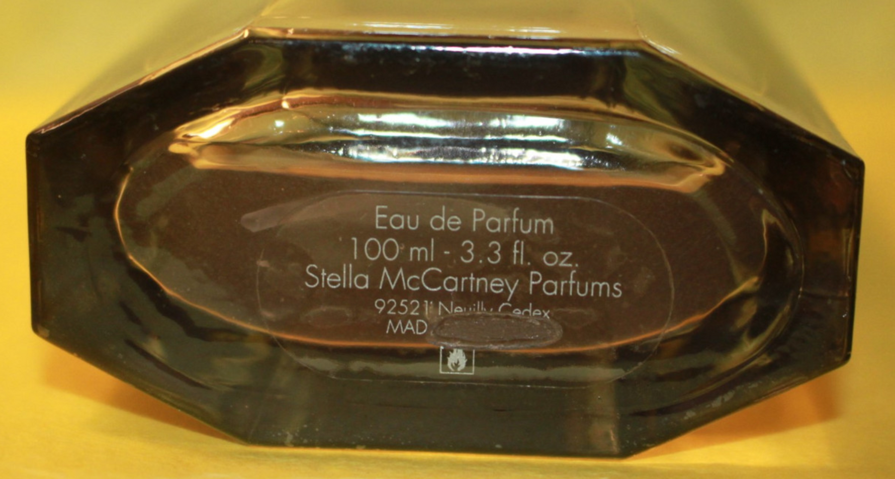 Bottom of perfume bottle with batch scratched off